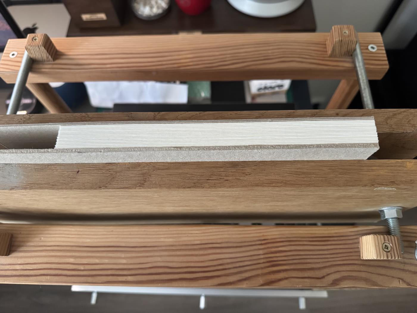 The text block clamped in a wooden sewing frame