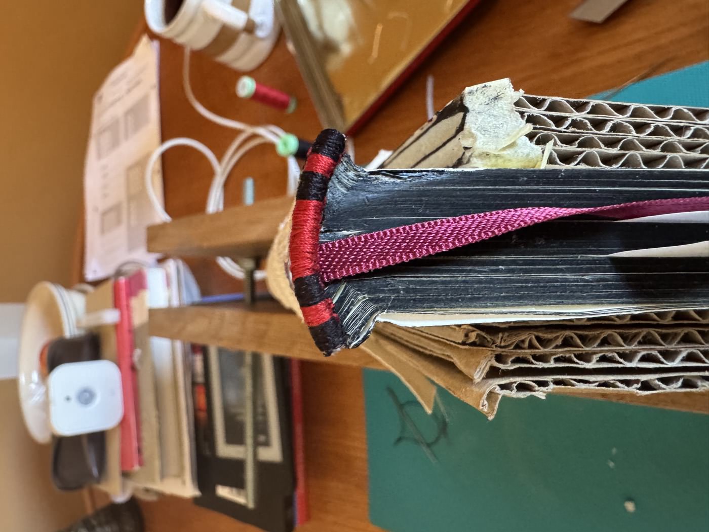 Hand-sewing the headbands in red and black thread